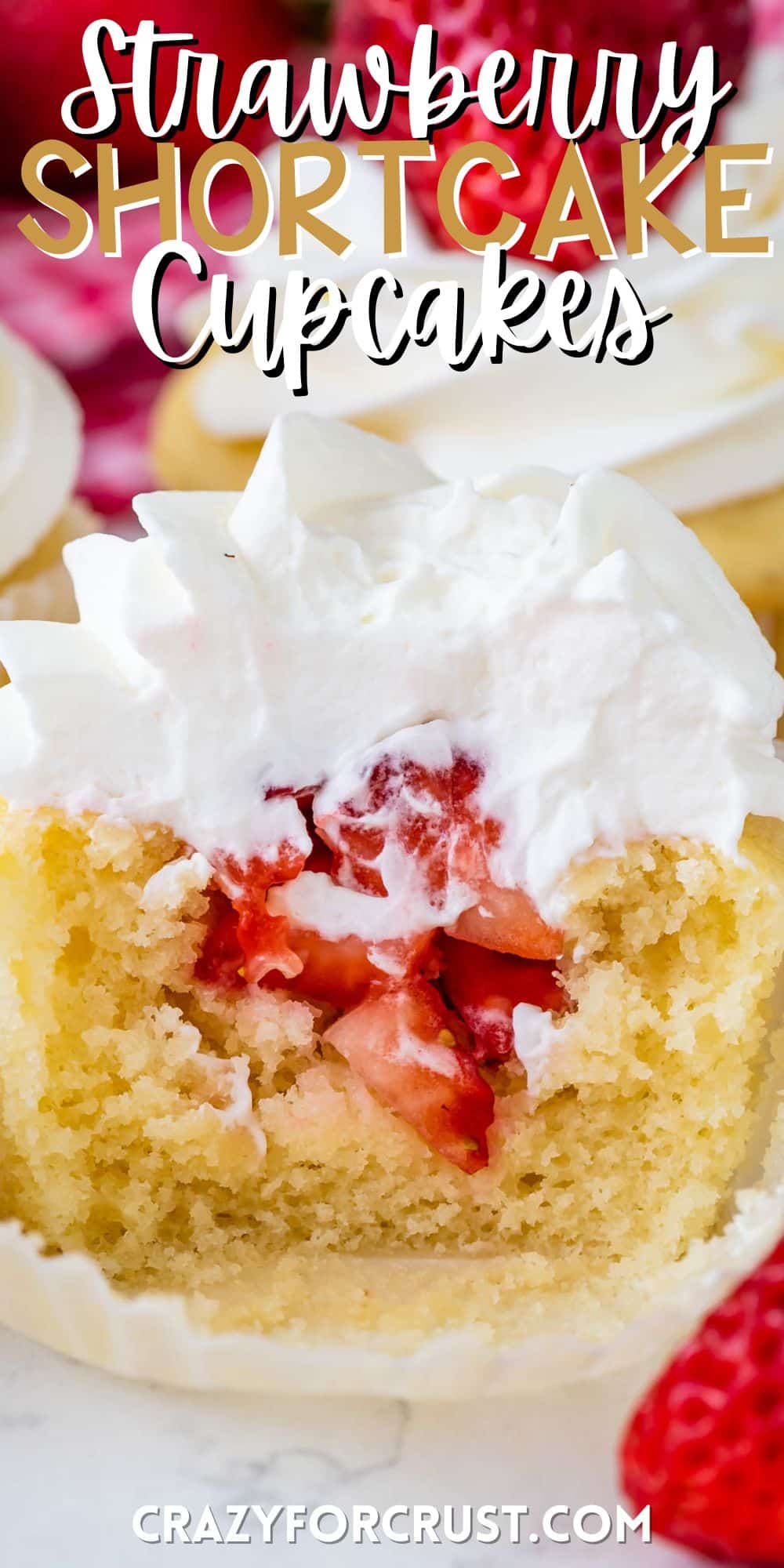 cupcakes with chopped strawberries in the center and topped with white frosting with words and the frosting.