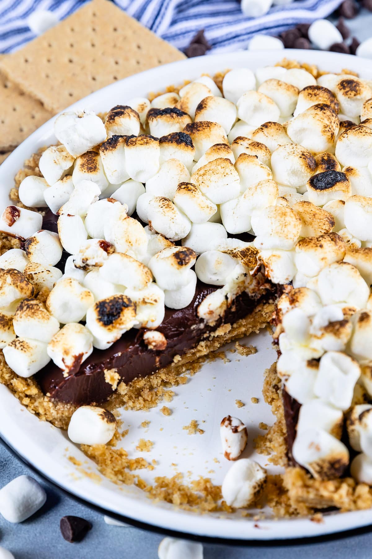 s'mores pie topped with many marshmallows in a white pie plate.