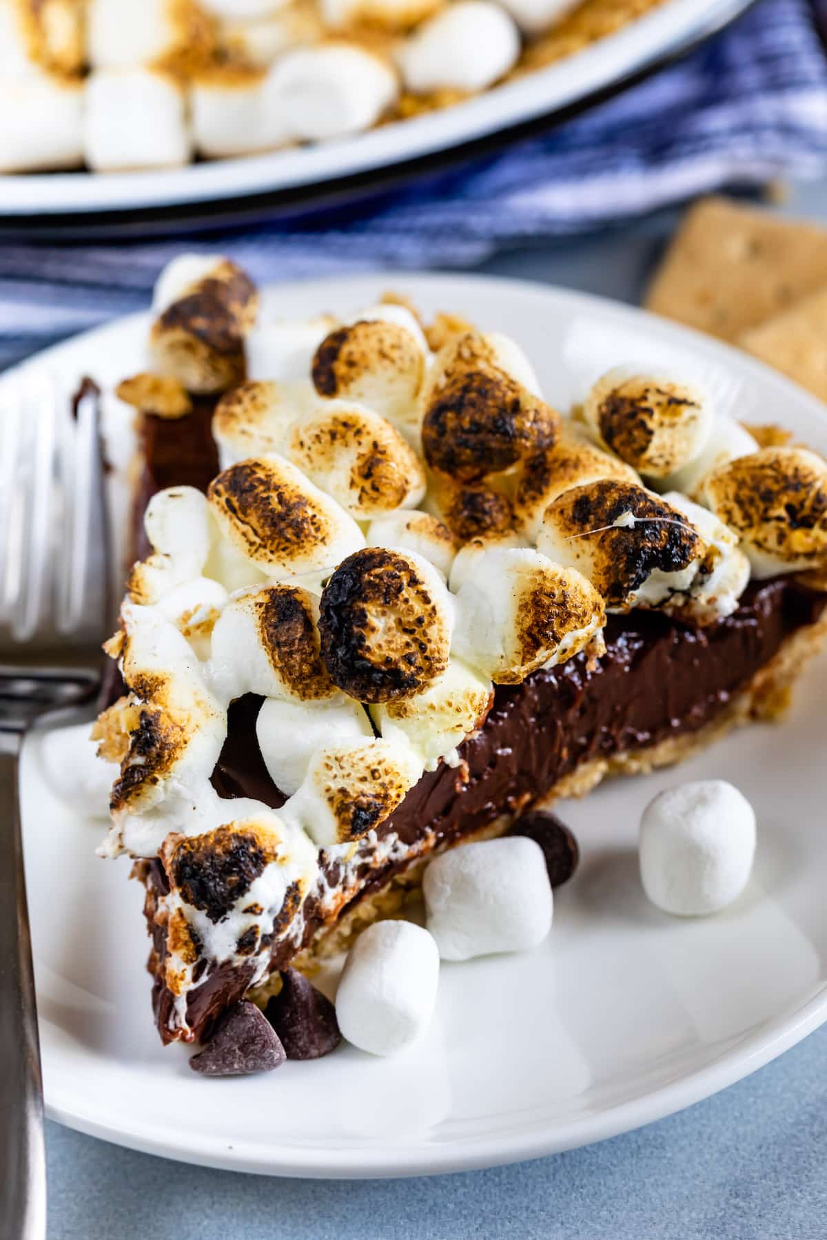 s'mores pie topped with many marshmallows in a white pie plate.