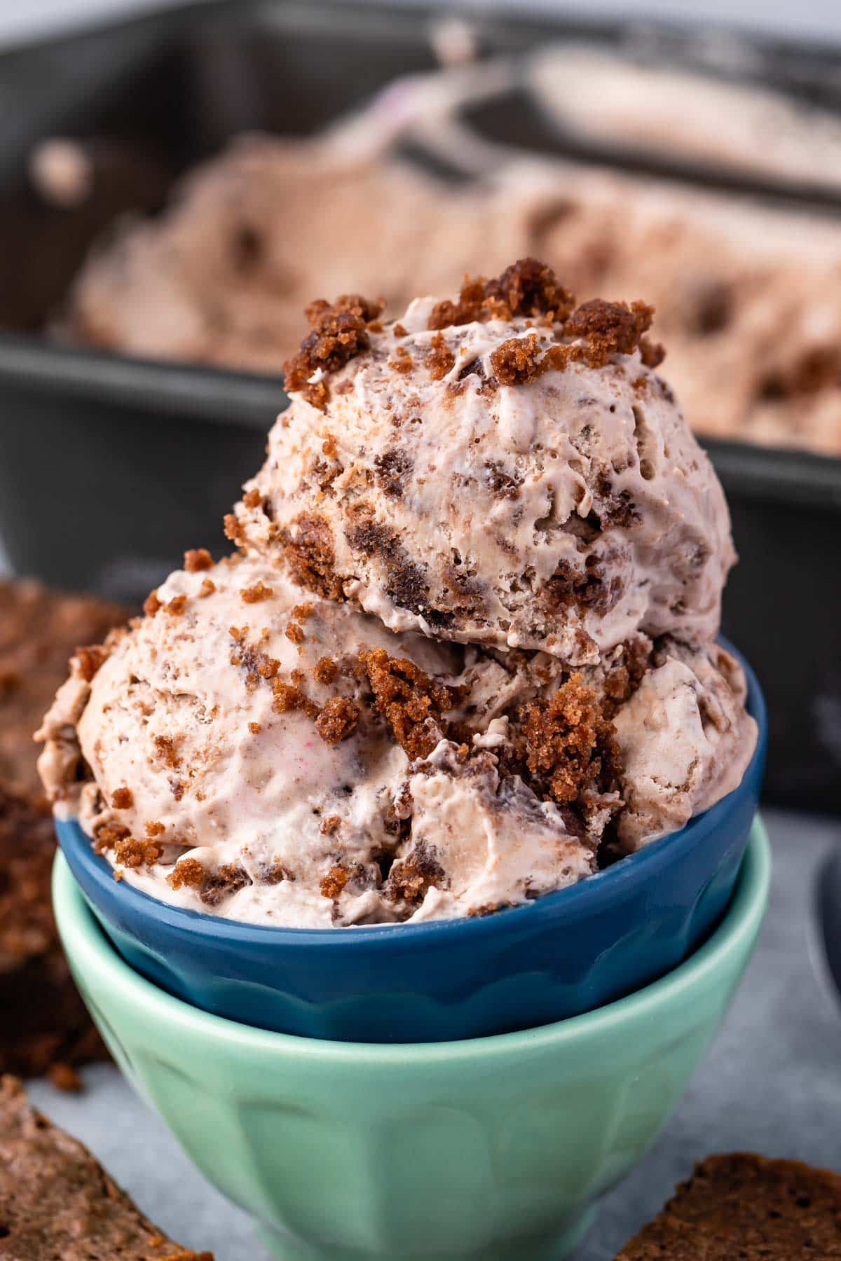 scoops of brown brownie batter ice cream in two stacked bowls.