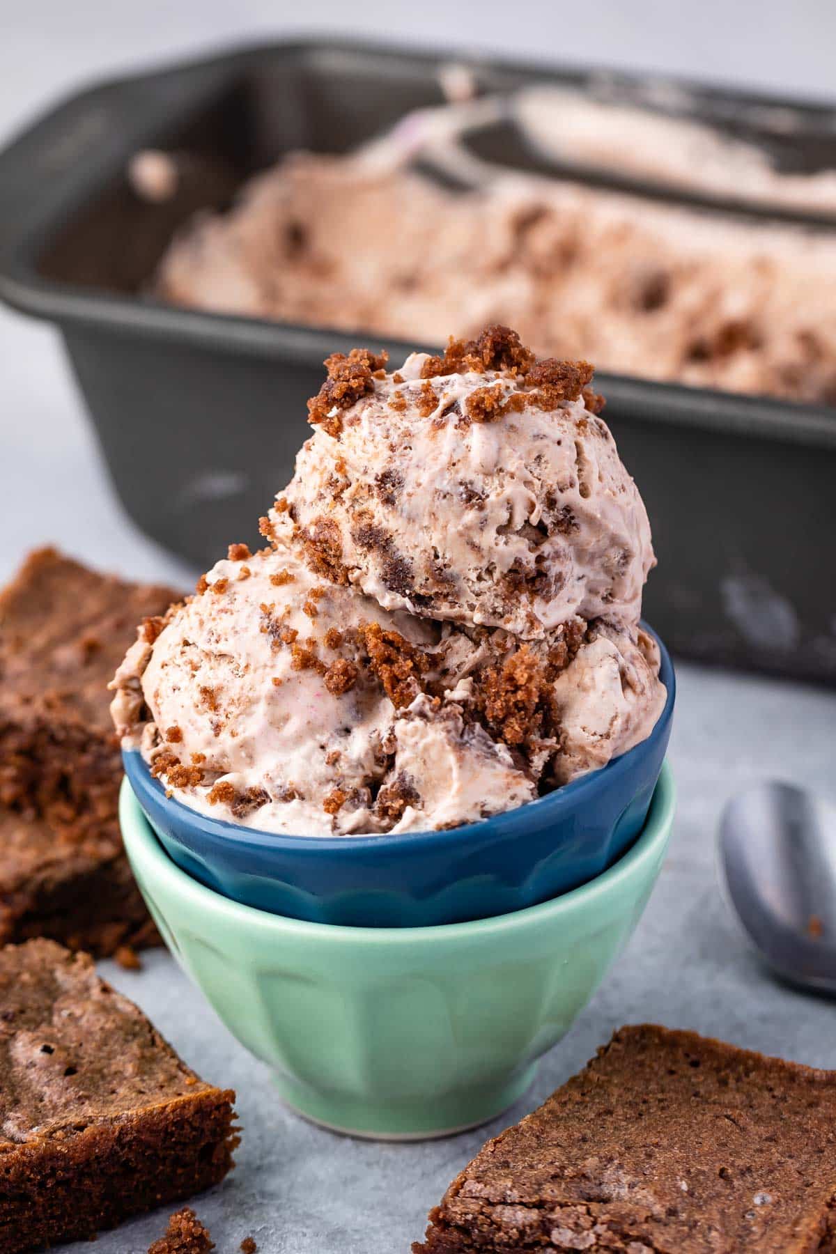 scoops of brown brownie batter ice cream in two stacked bowls.
