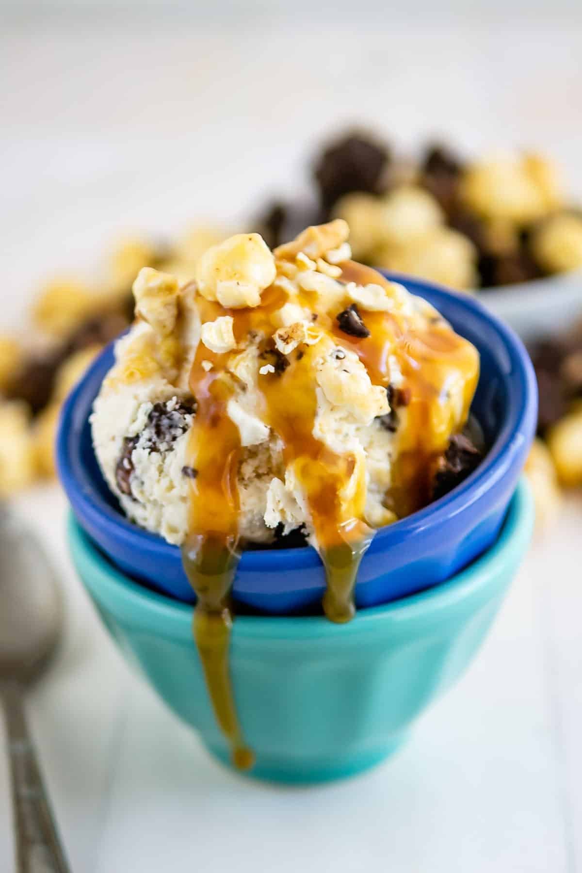 stacked blue bowls with ice cream in the bowls topped with caramel.