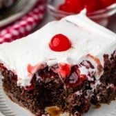 cherry coke cake topped with white topping and a cherry.