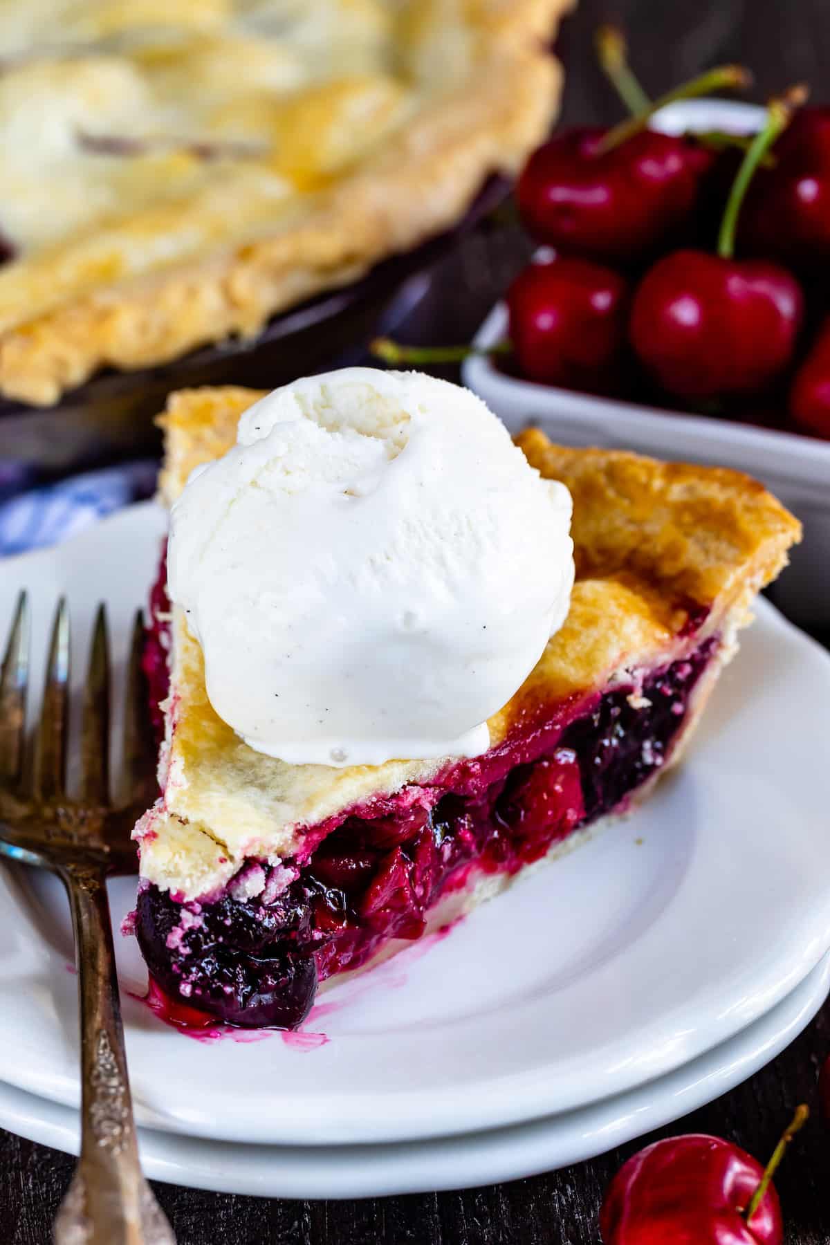 cherry pie with cherry pie filling in the crust with ice cream on top.