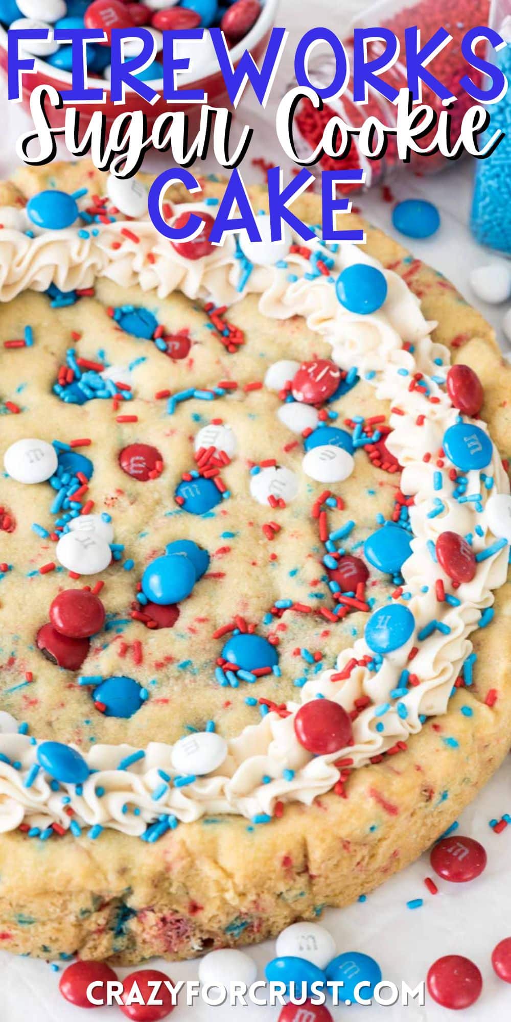 cookie cake with sprinkles baked in and topped with m&ms with words on the image.