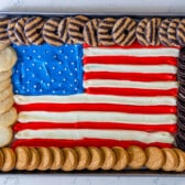 american flag made up out of frosting and surrounded by Girl Scout cookies.