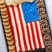 american flag made up out of frosting and surrounded by Girl Scout cookies.