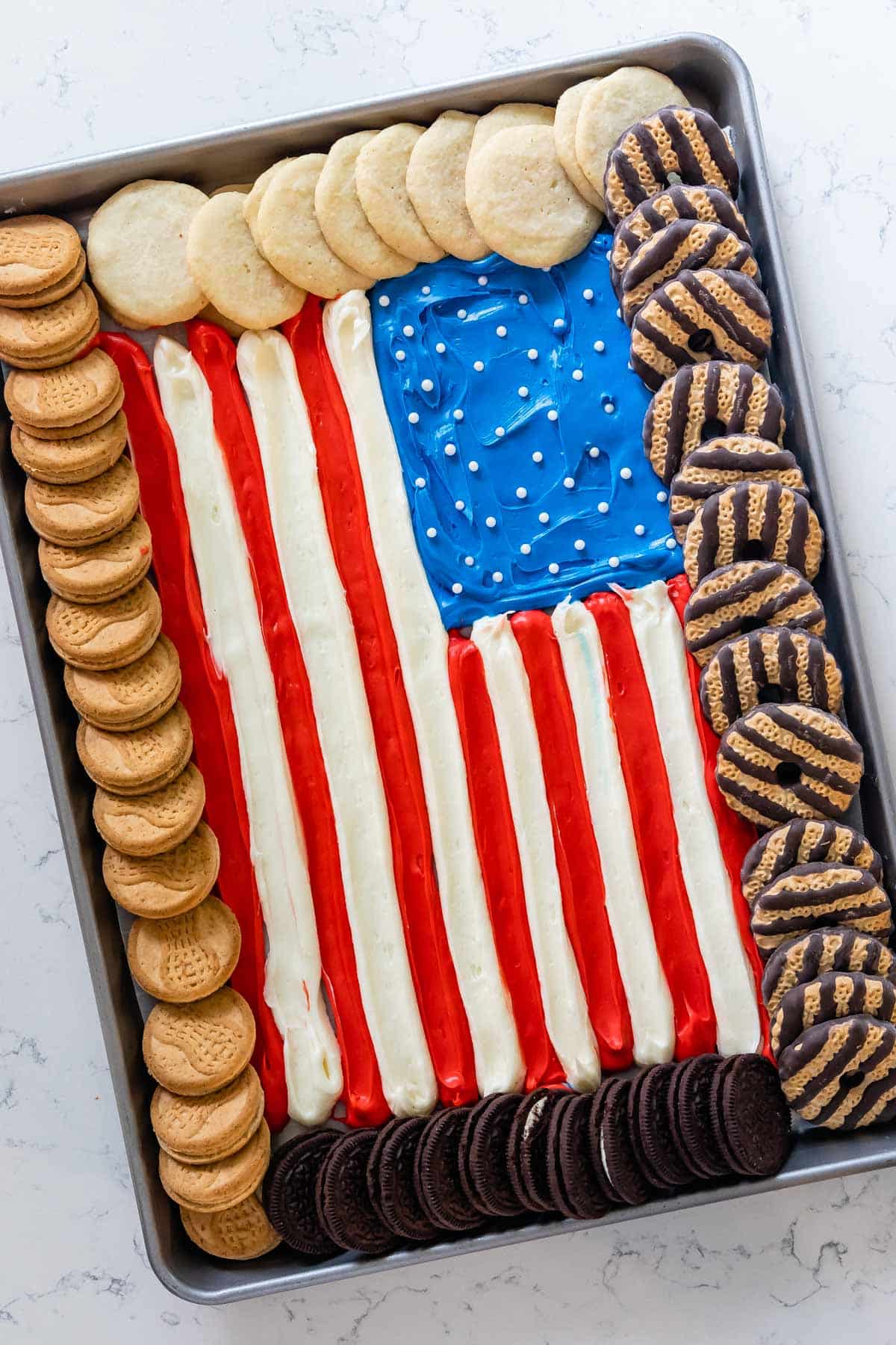 american flag made up out of frosting and surrounded by Girl Scout cookies.