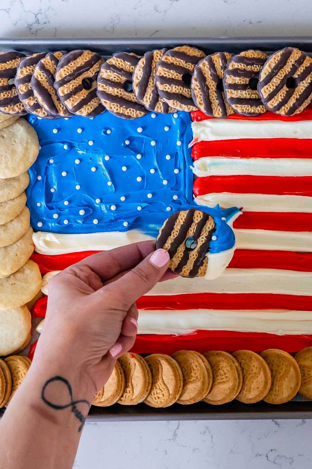 american flag made up out of frosting and surrounded by Girl Scout cookies.