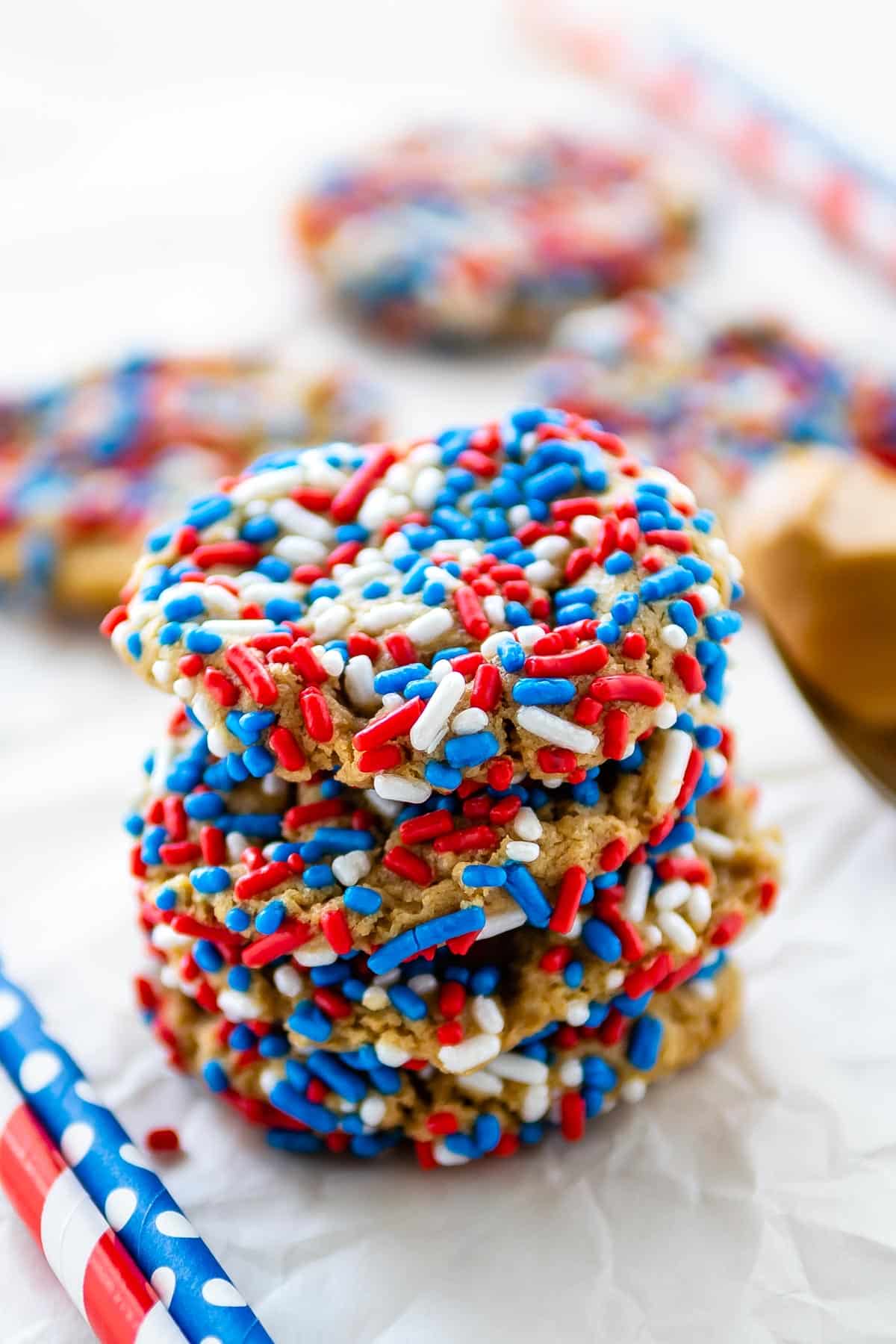 stack of 4 cookies with red white and blue sprinkles.