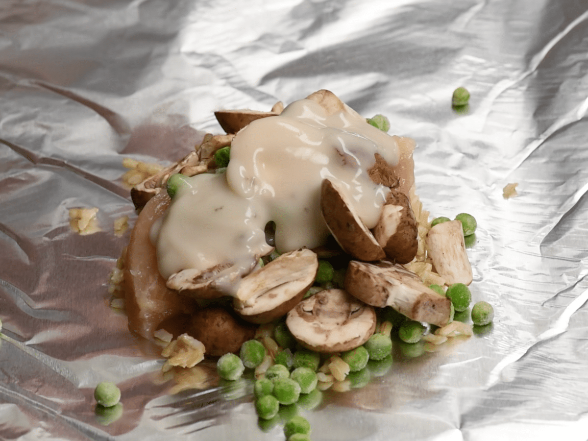 chicken and mushrooms and peas and rice on foil.