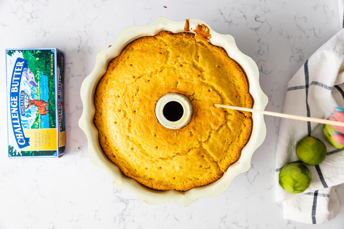 poking holes in cake in bundt pan with skewer.