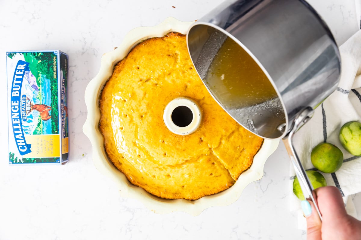 pouring pan with syrup over cake in pan.