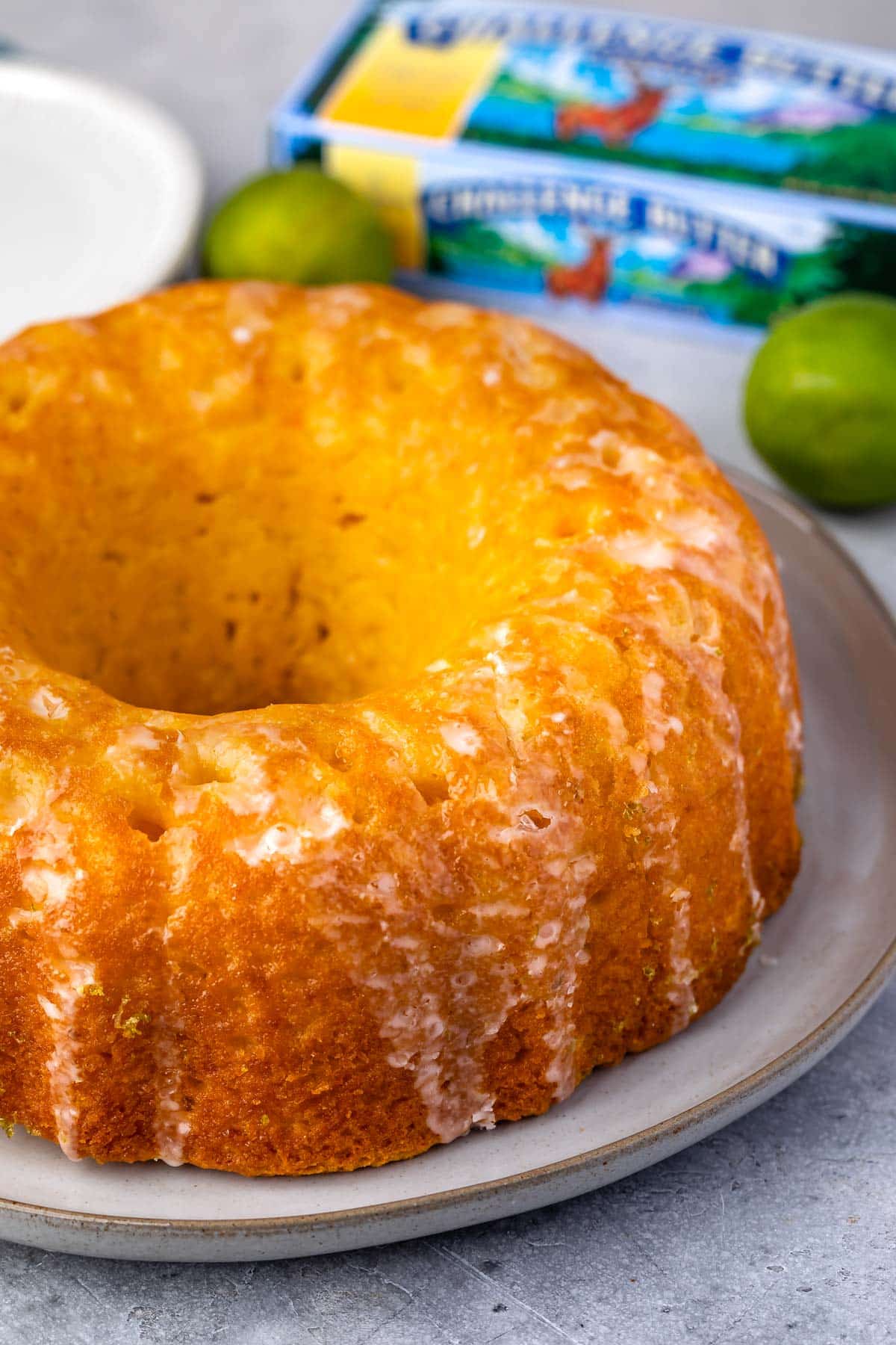 cake on white plate with butter box and limes behind.