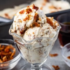 ice cream in a clear ice cream glass topped with bacon.