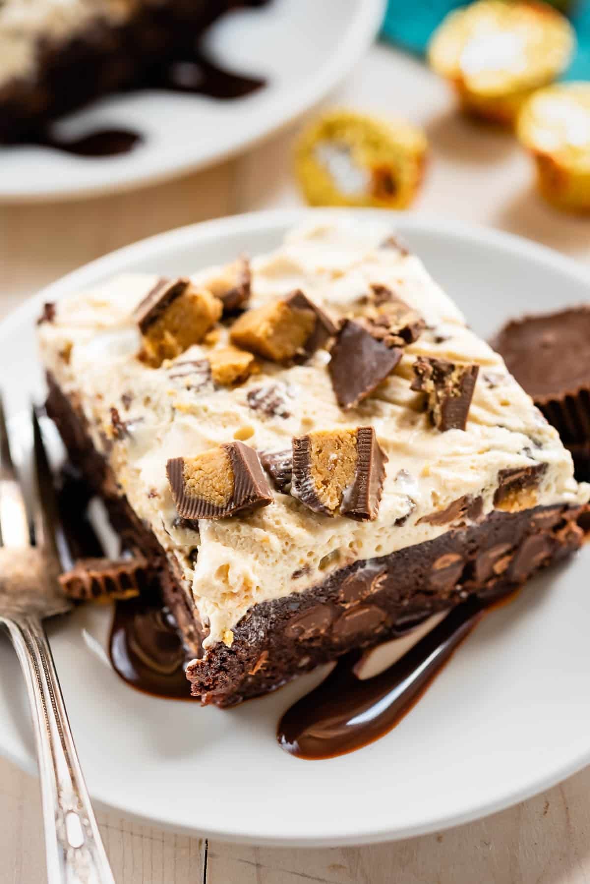 square slice of ice cream brownies on a white plate next to a fork.