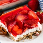 strawberries layered with crust and filling on a plate.