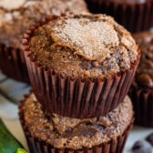 stacked chocolate muffins in brown cupcake wrappers.