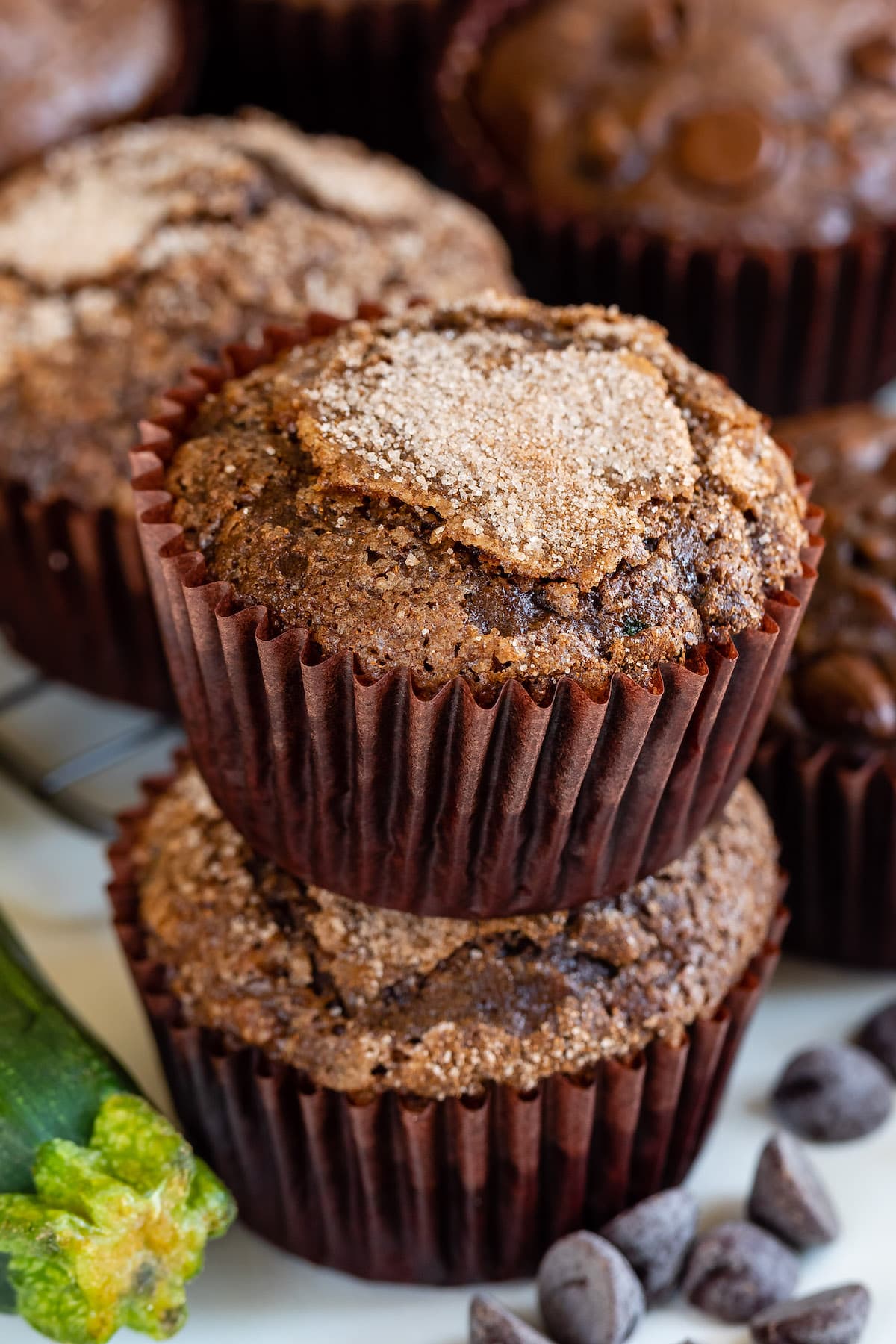 stacked chocolate muffins in brown cupcake wrappers.