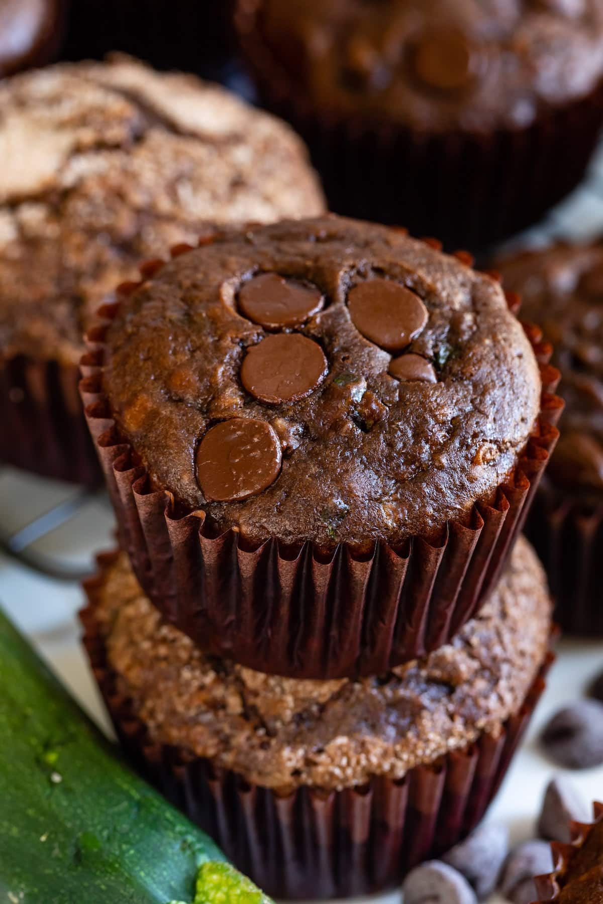 stacked chocolate muffins in brown cupcake wrappers.