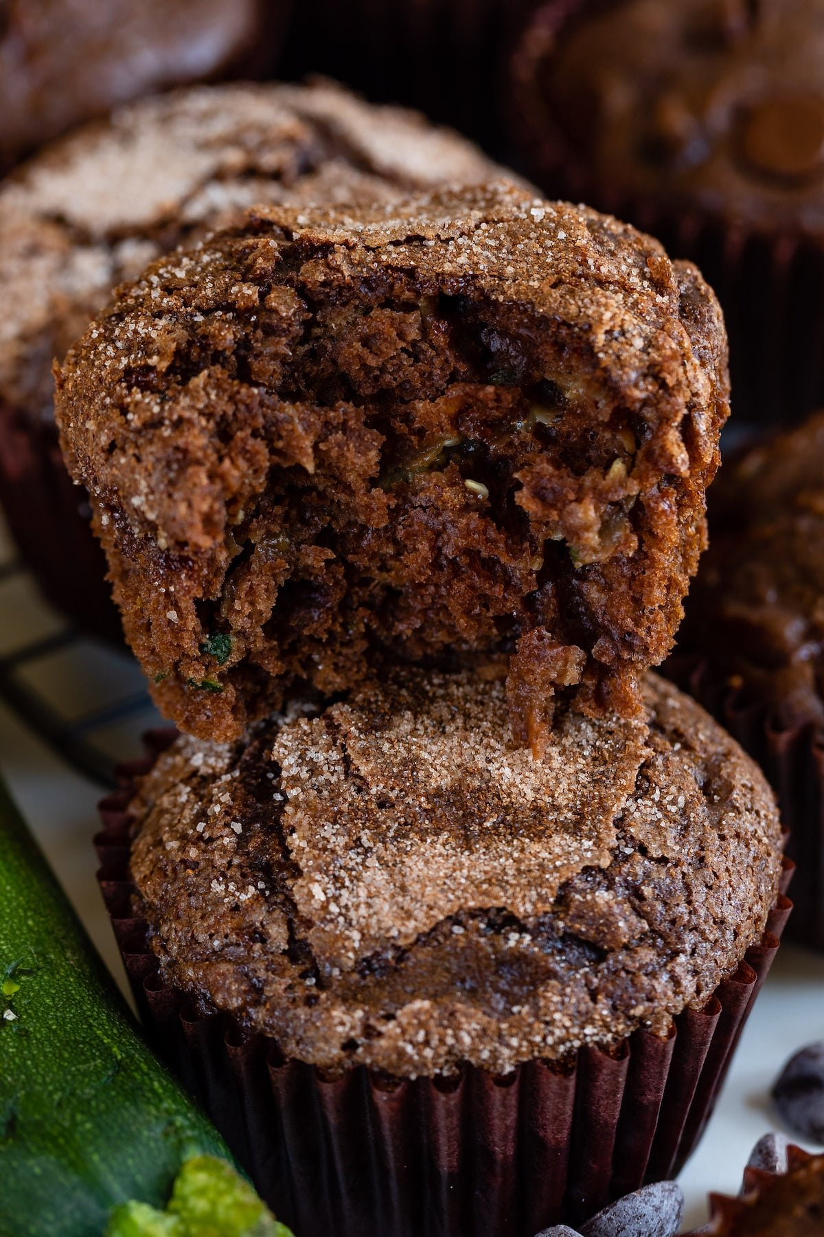 stacked chocolate muffins in brown cupcake wrappers.