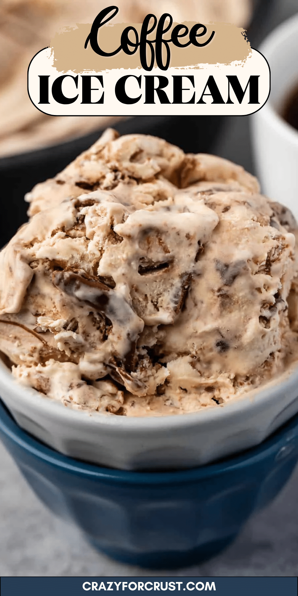 Gros plan d'un bol rempli de glace au café crémeuse, parsemée de morceaux de chocolat, servie dans un bol blanc sur un bol bleu. Le texte ci-dessus met en avant la glace au café.