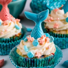cupcakes in scaled cupcake wrappers with candy mermaid tails on top.
