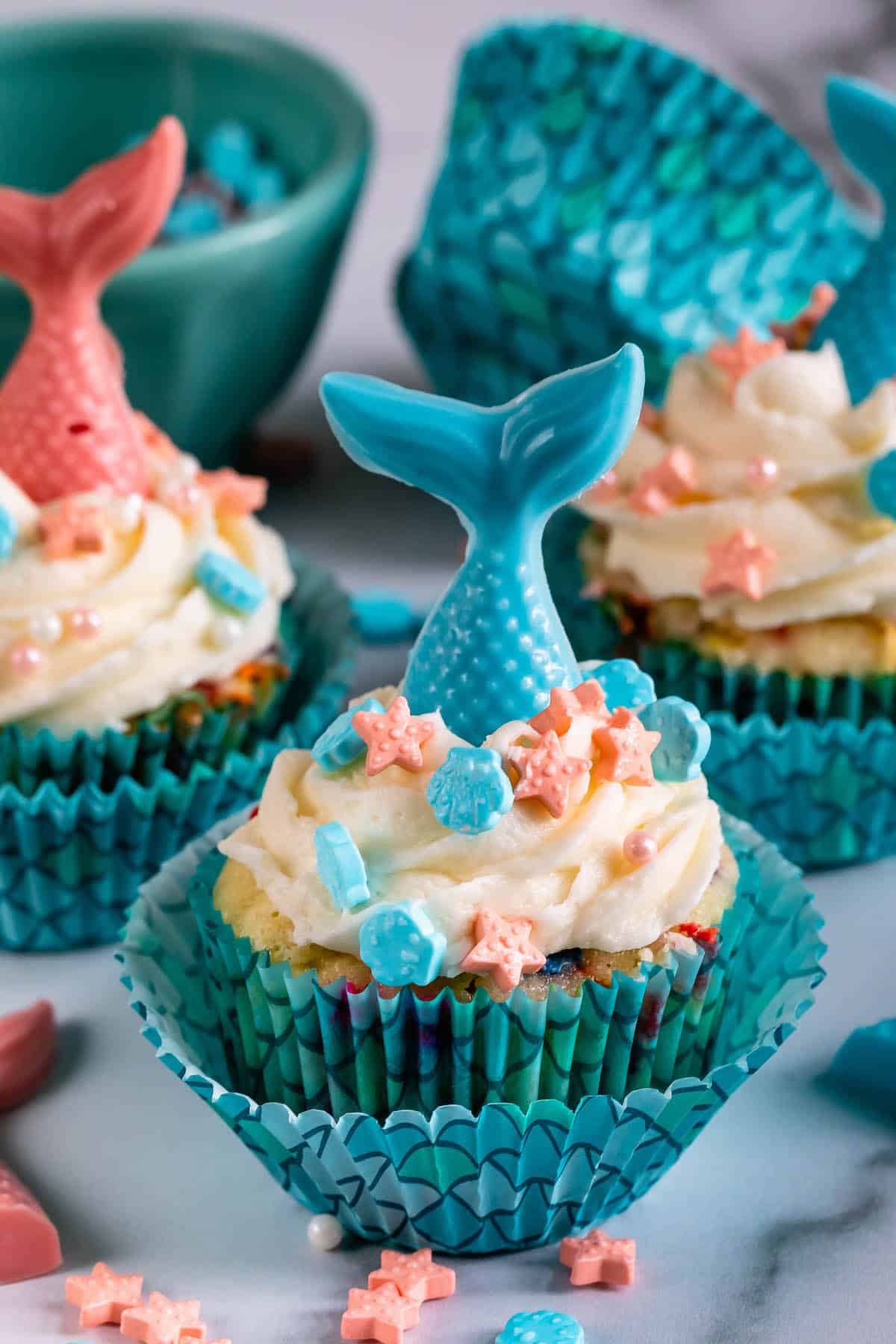 cupcakes in scaled cupcake wrappers with candy mermaid tails on top.