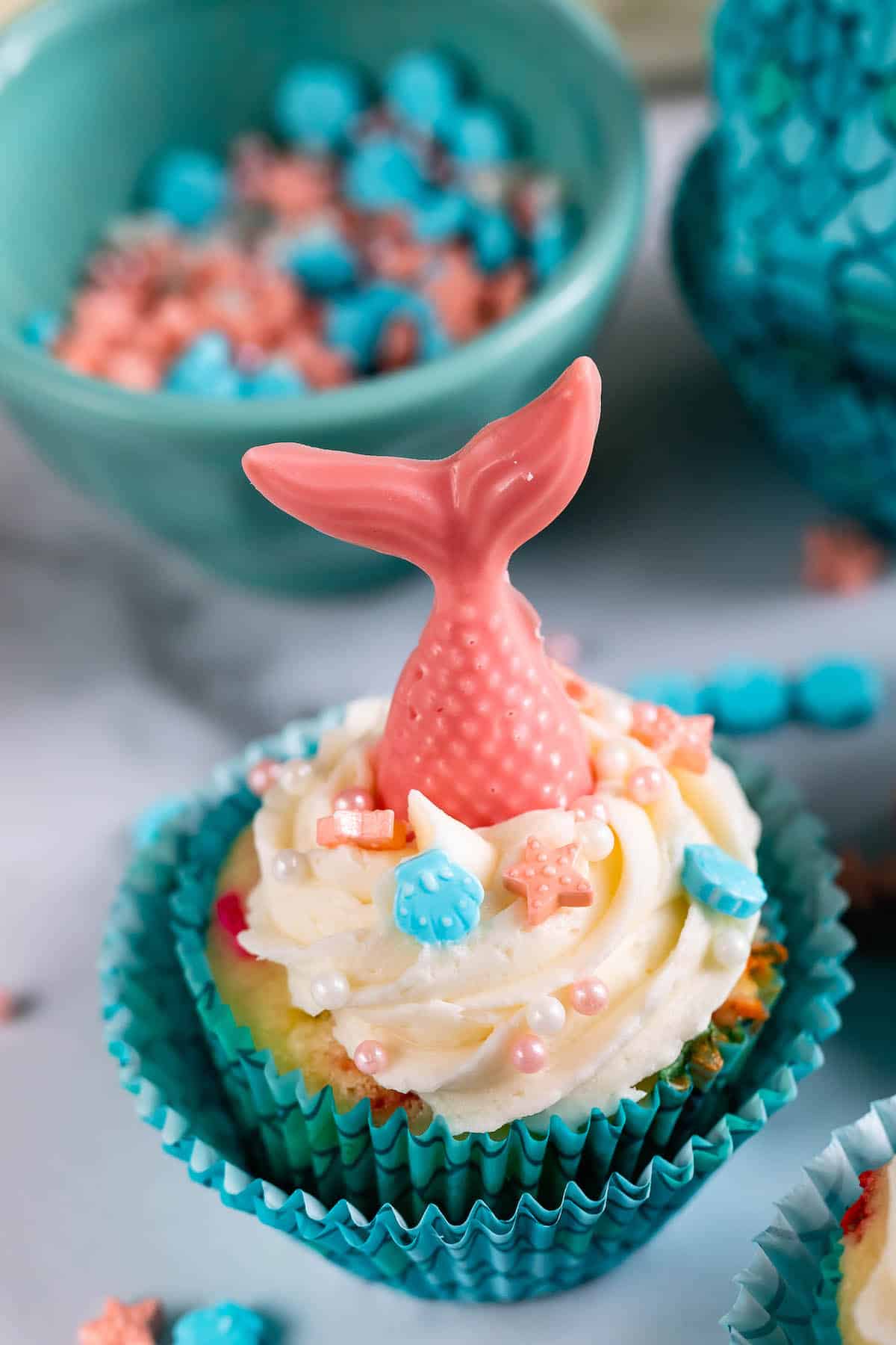 cupcakes in scaled cupcake wrappers with candy mermaid tails on top.