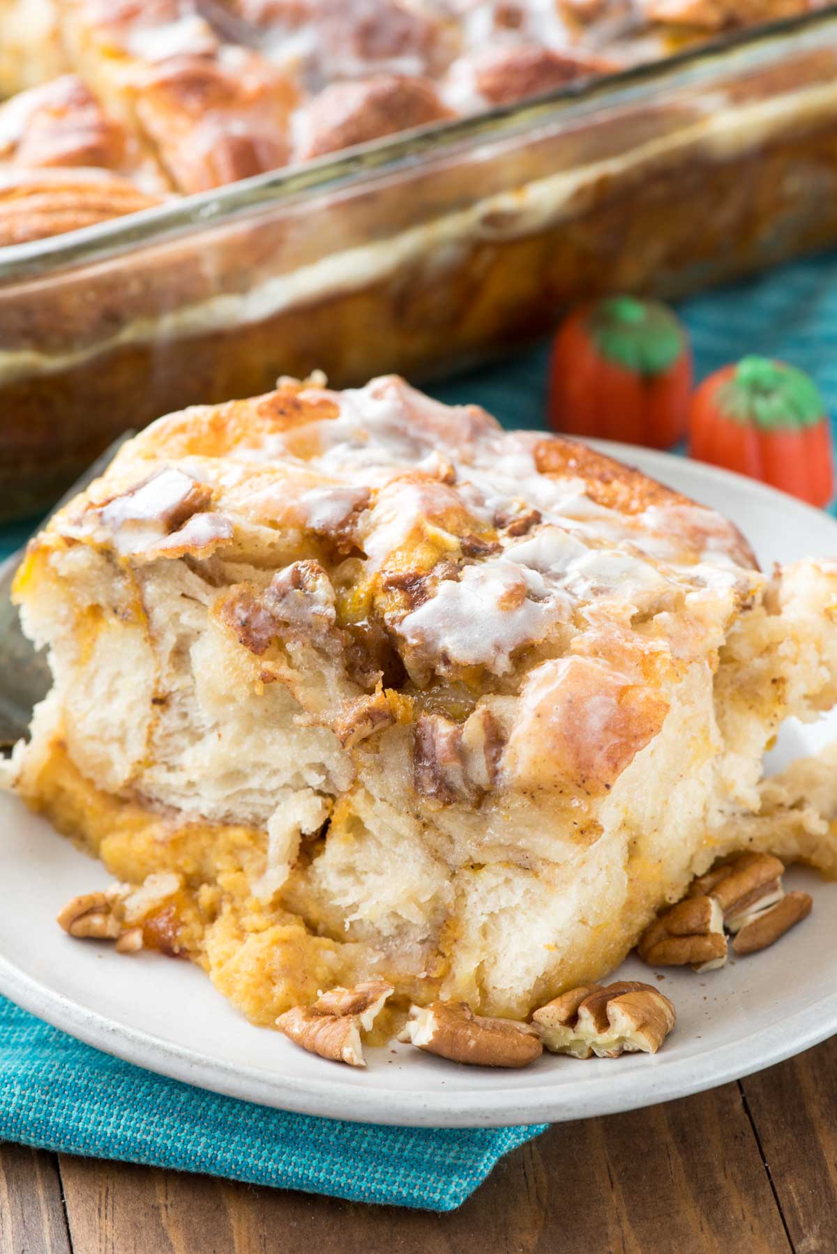 pumpkin monkey bread on a white plate with nuts sprinkled around.