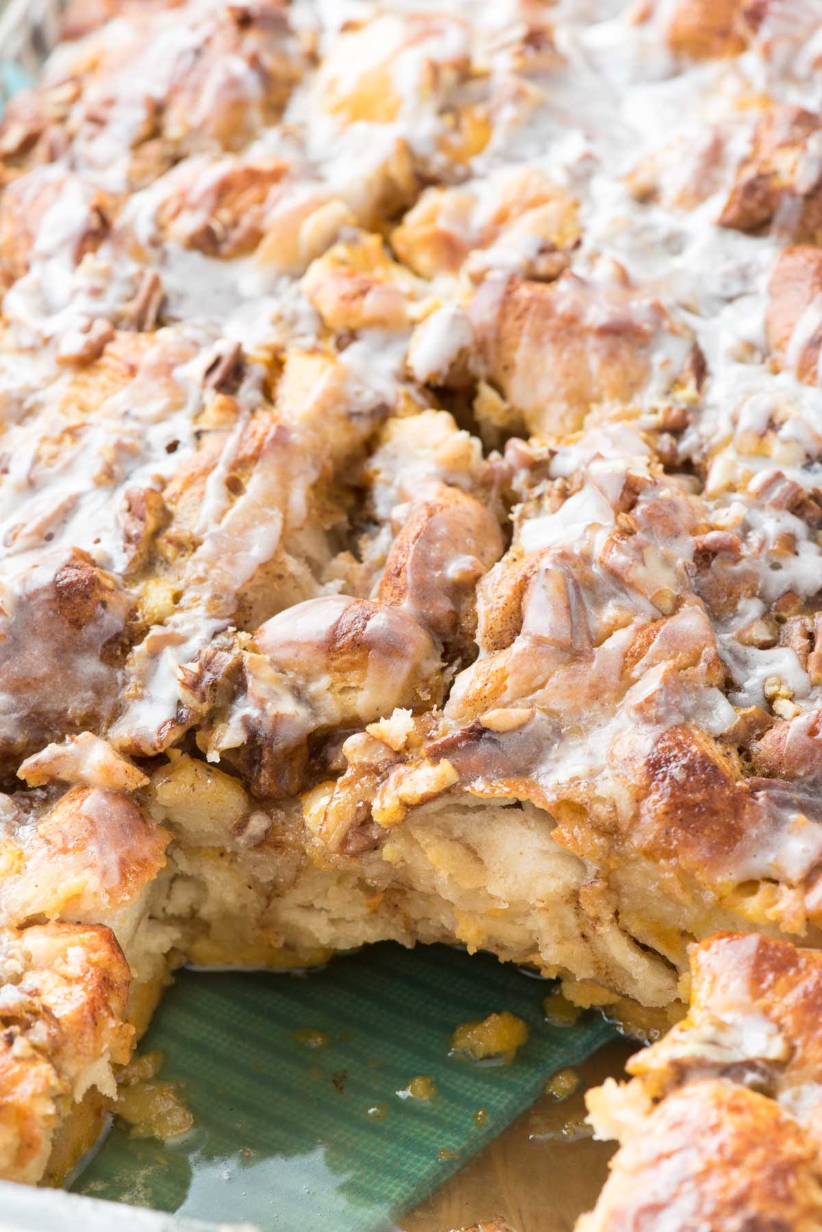 pumpkin monkey bread in a clear pan with nuts sprinkled around.