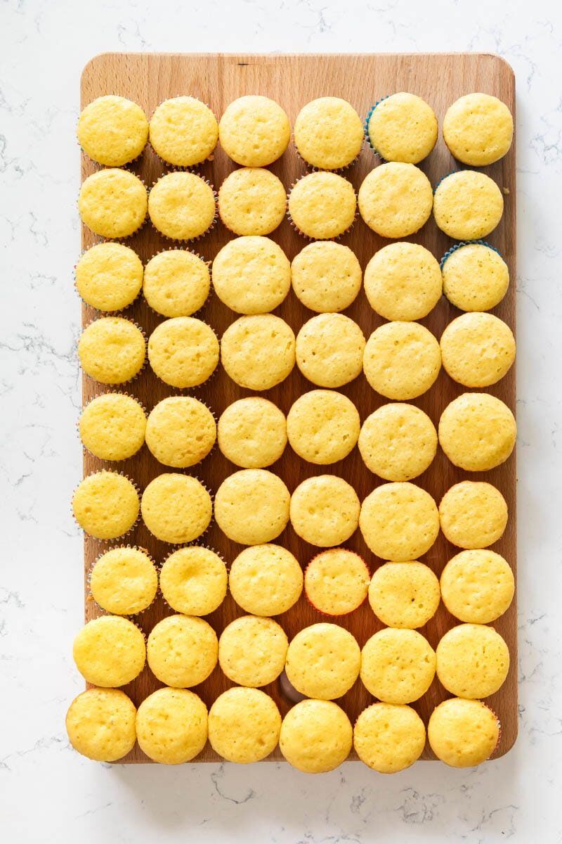 Overhead shot of vanilla cupcakes lined up on cutting board before being decorated