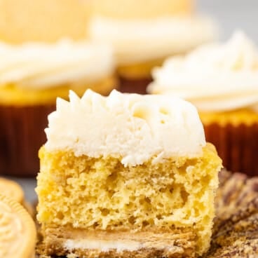 banana cupcakes next to golden oreos with white frosting.