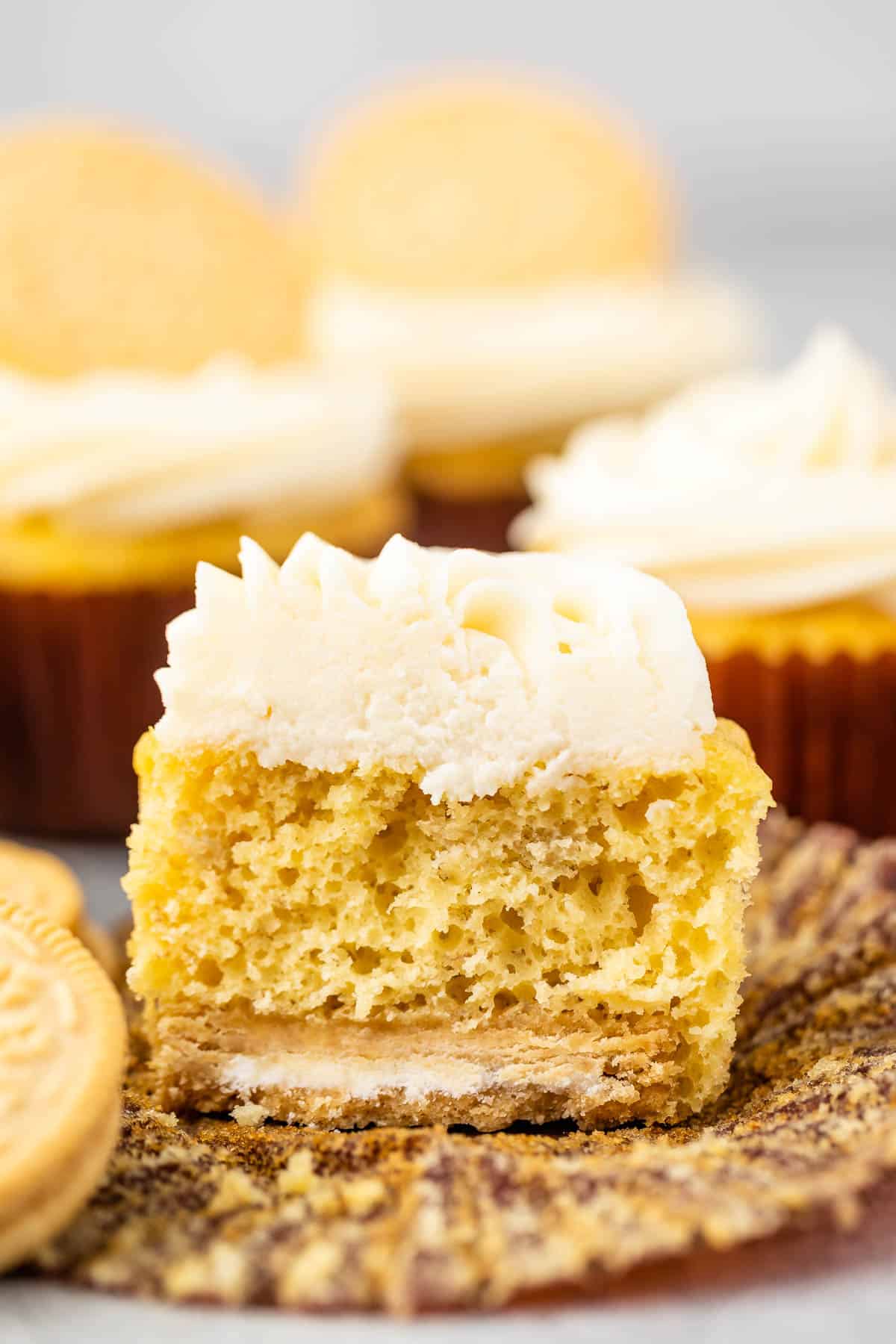 banana cupcakes next to golden oreos with white frosting.