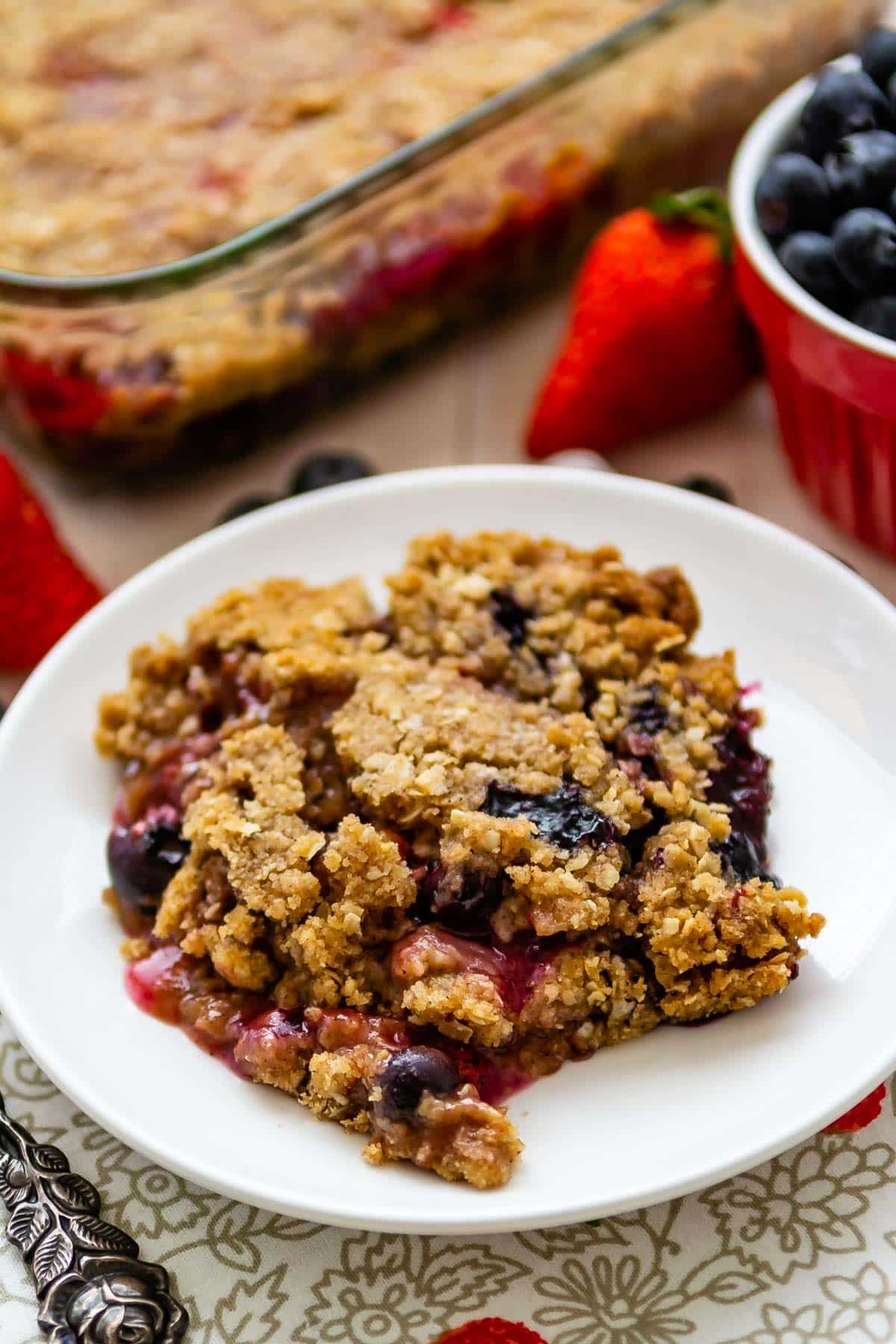 berry crisp on a white plate mixed with various berries.
