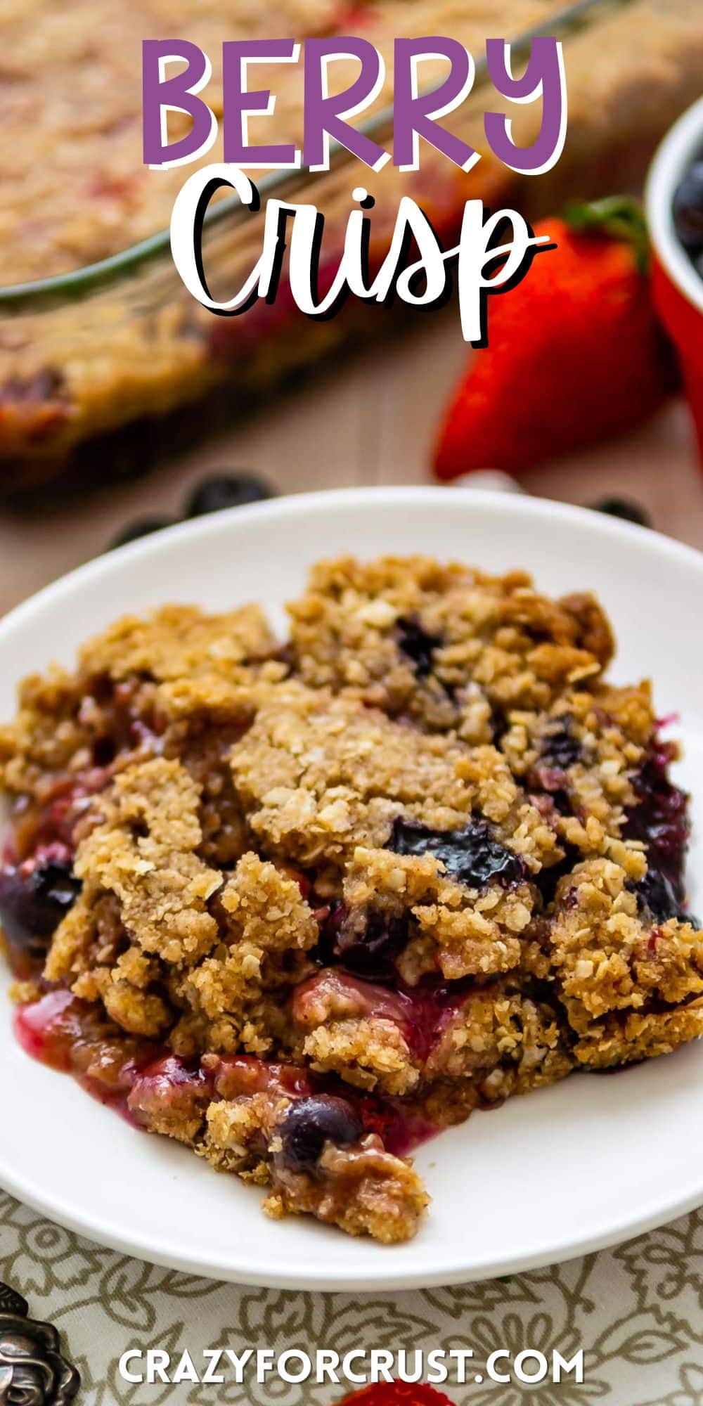 berry crisp on a white plate mixed with various berries with words on the image.