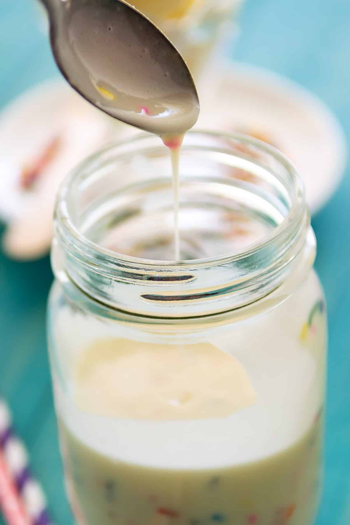 magic shell in a clear mason jar being scooped with a spoon.