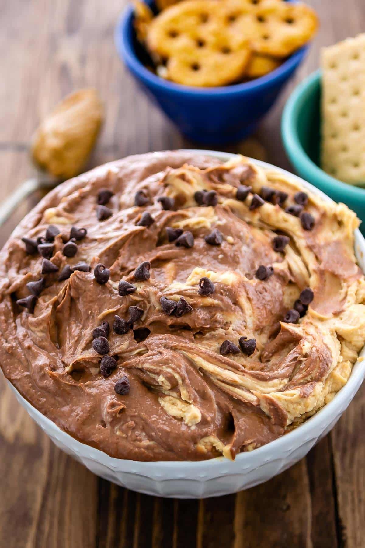 dip in a white bowl with mini chocolate chips sprinkles on top.
