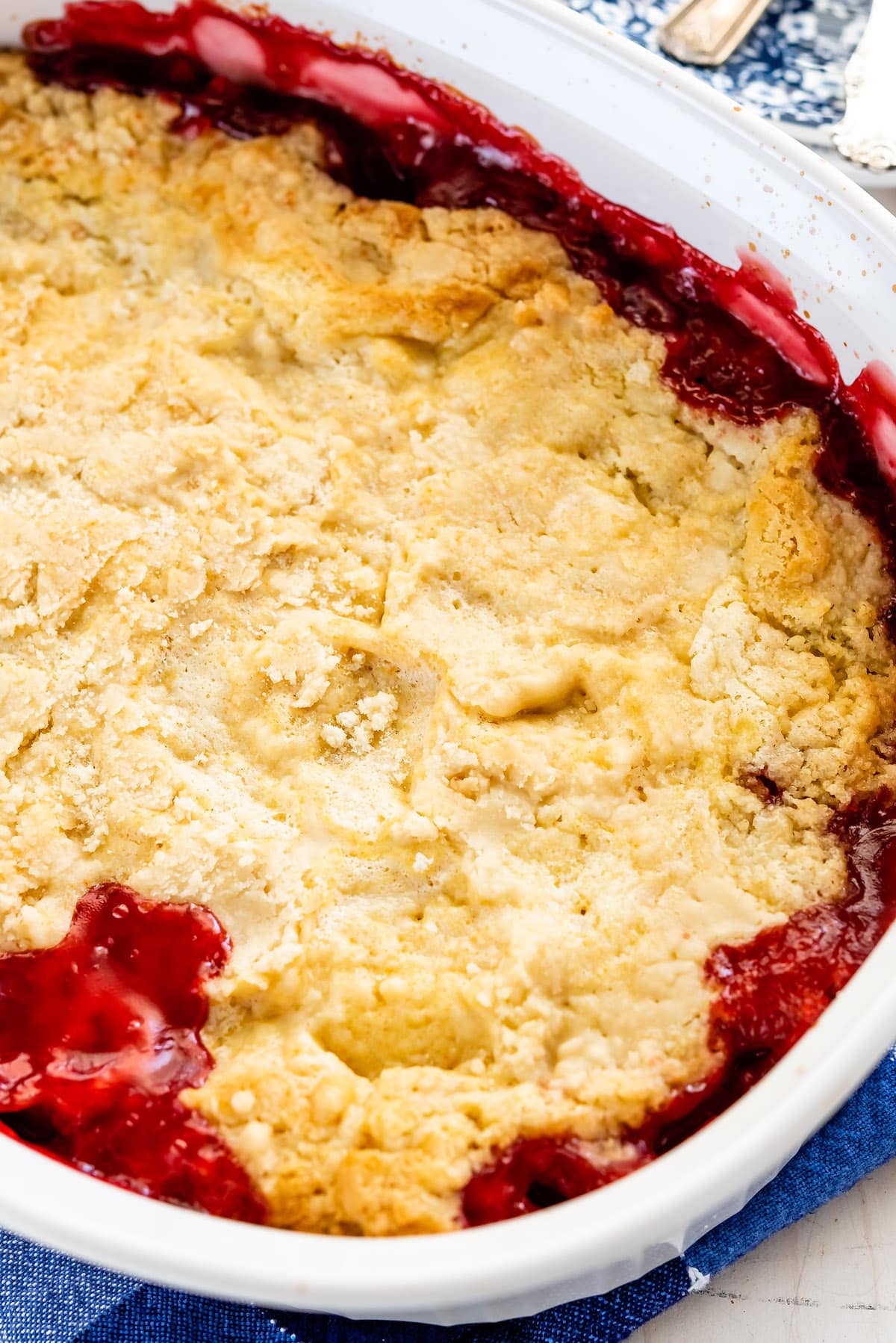 yellow and red dump cake in a white pan.