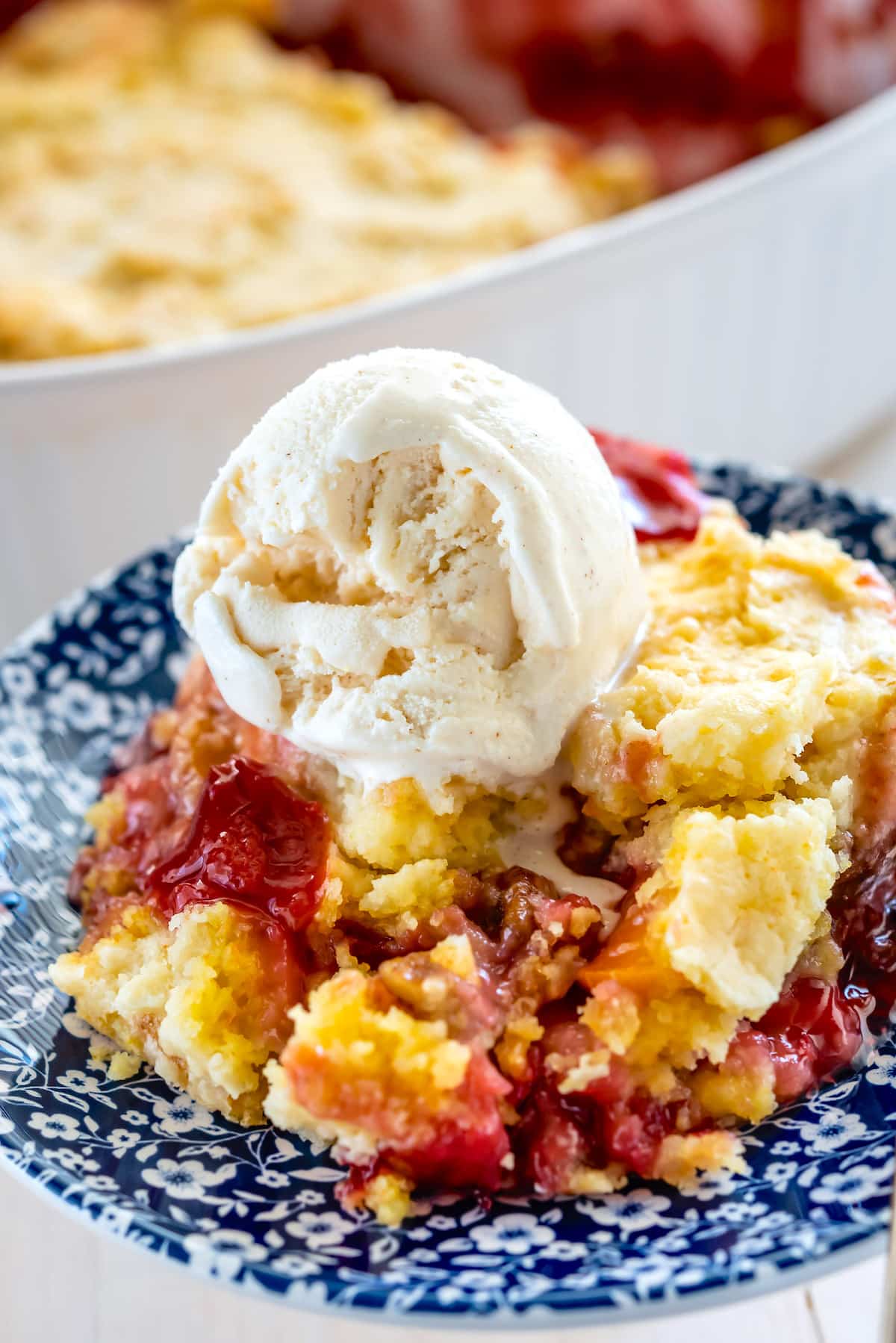 yellow and red dump cake with a scoop of vanilla on the cake.