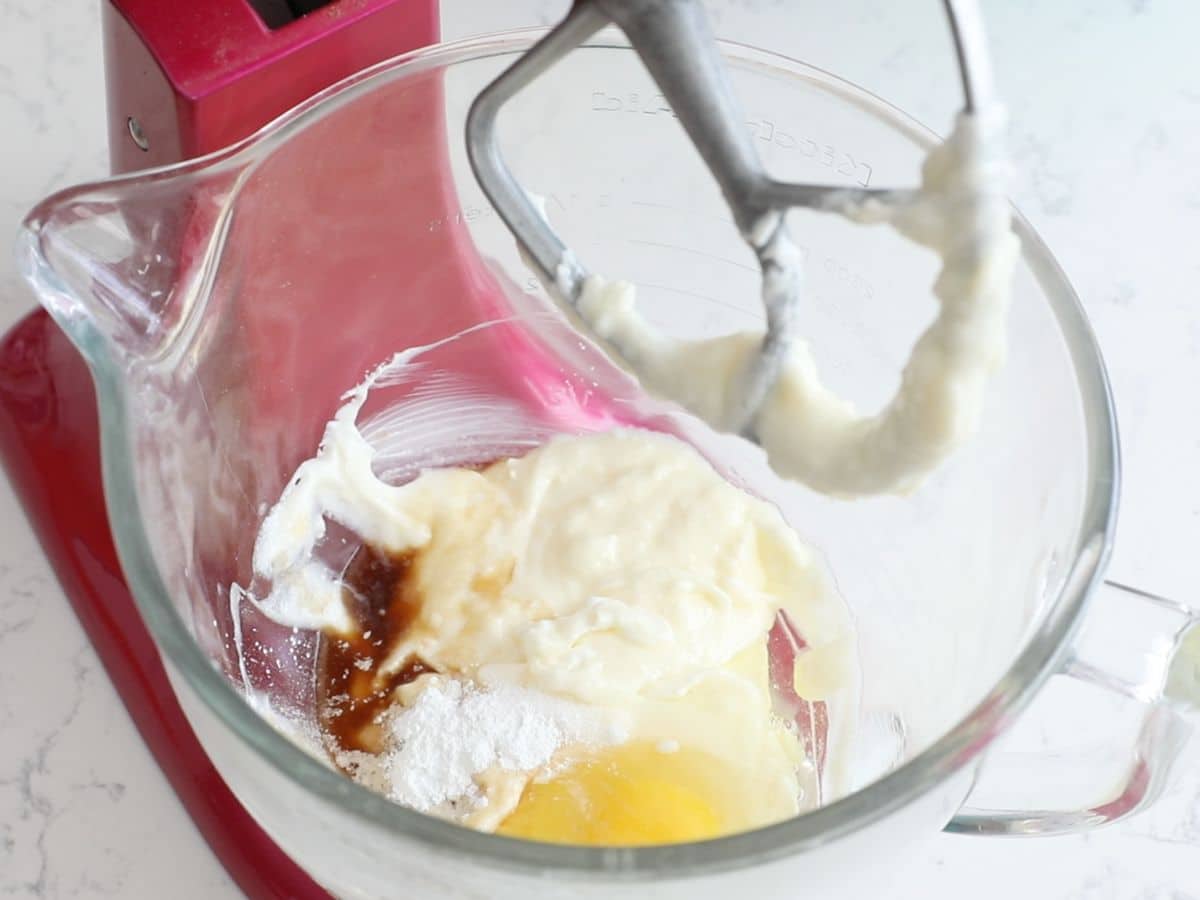 bowl in mixer with sour cream mixture, egg, baking powder and vanilla