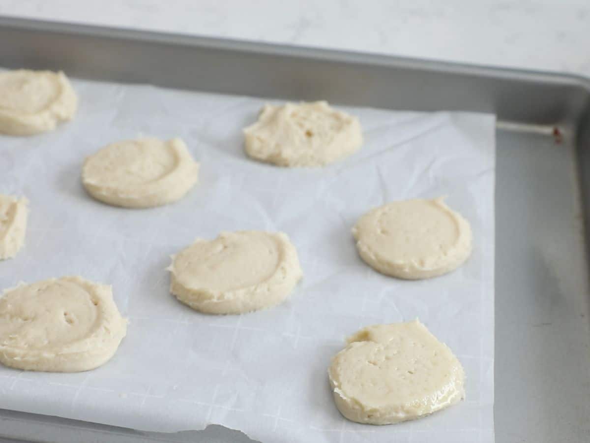 cookies flattened on parchment on cookie sheet