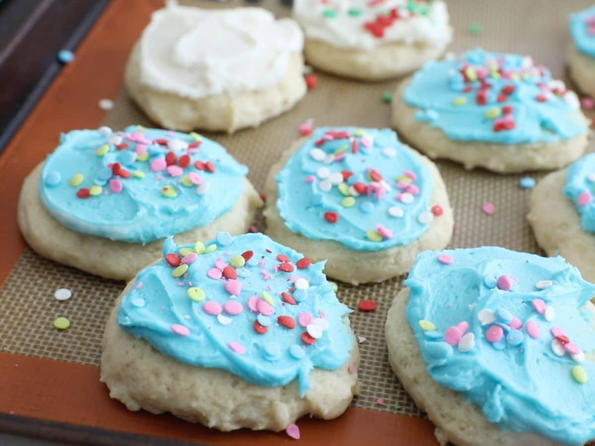 cookies with blue frosting on cookie sheet