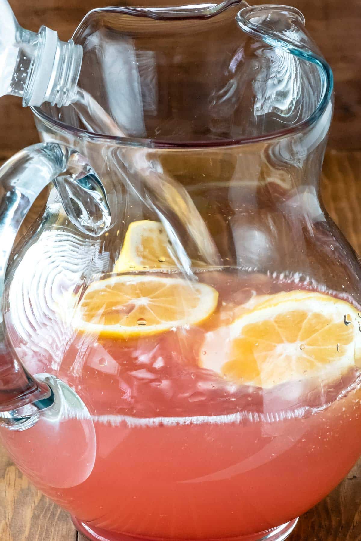 rose in clear pitcher with a lemon slices in the glass.