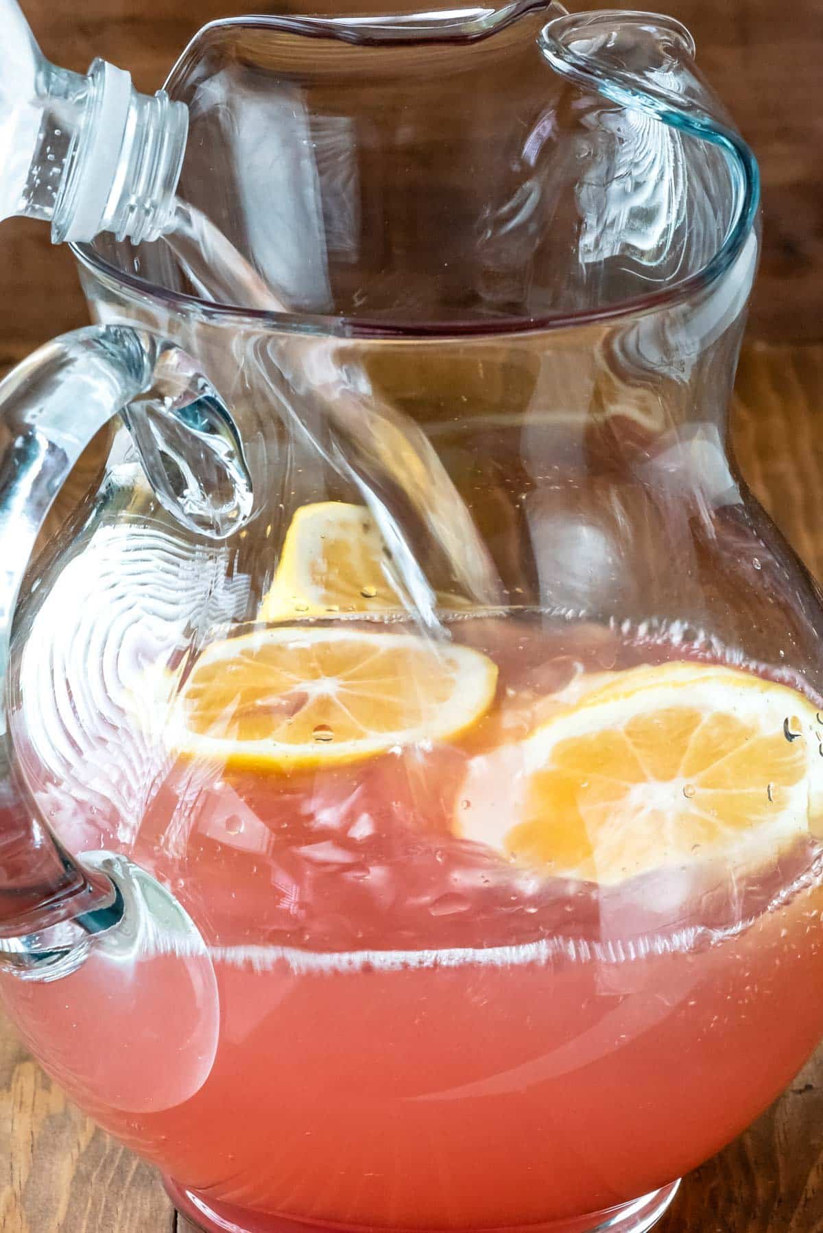 rose in clear pitcher with a lemon slices in the glass.