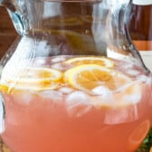 rose in clear pitcher with a lemon slices in the glass.