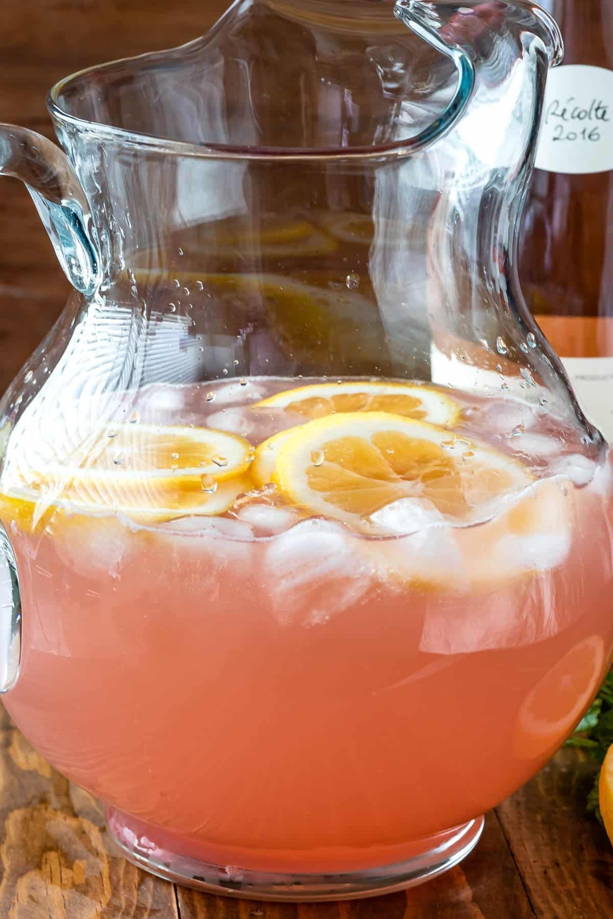 rose in clear pitcher with a lemon slices in the glass.