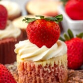 cupcake with white frosting and a strawberry on top.