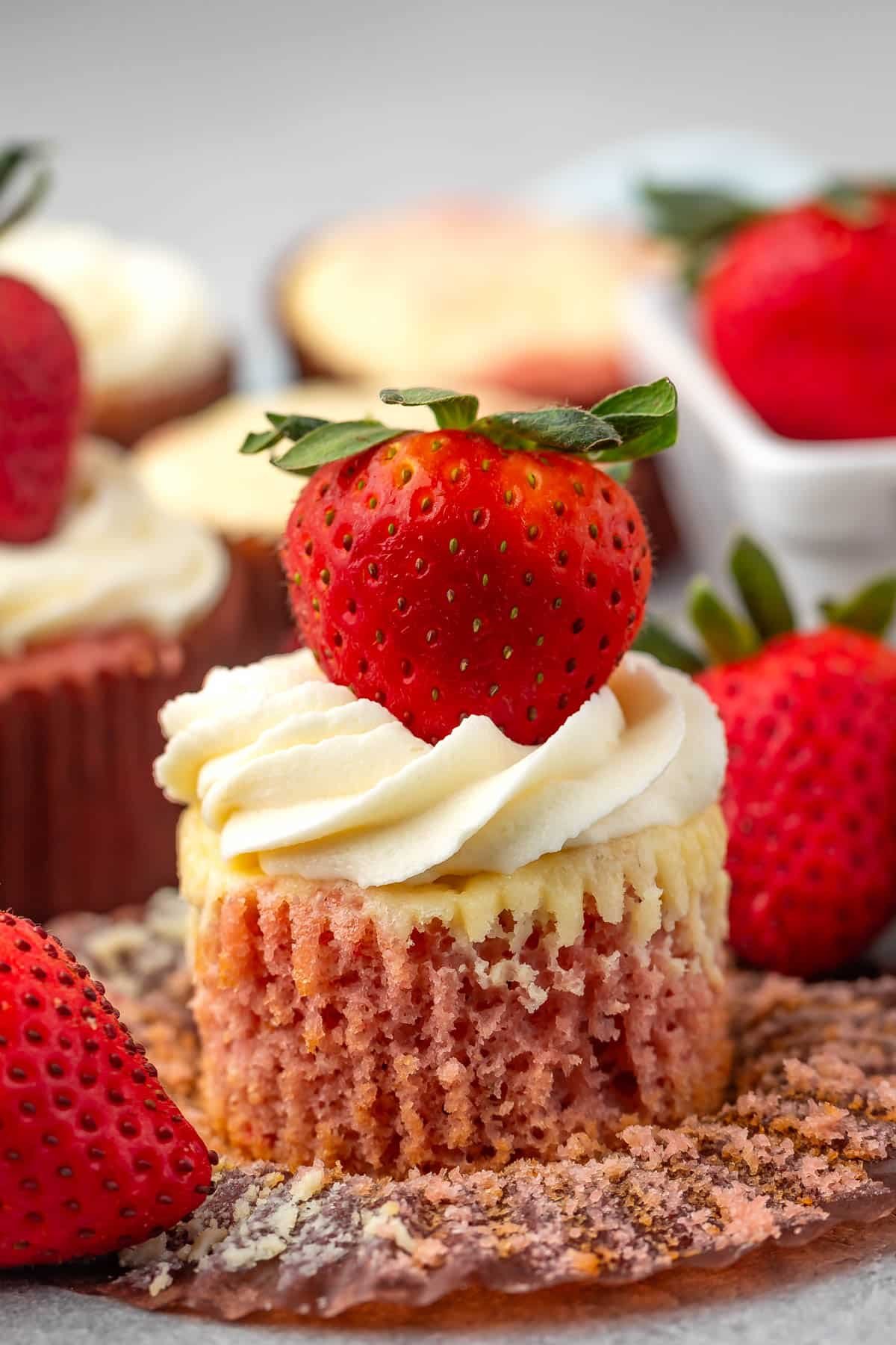 cupcake with white frosting and a strawberry on top.