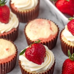 cupcake with white frosting and a strawberry on top.
